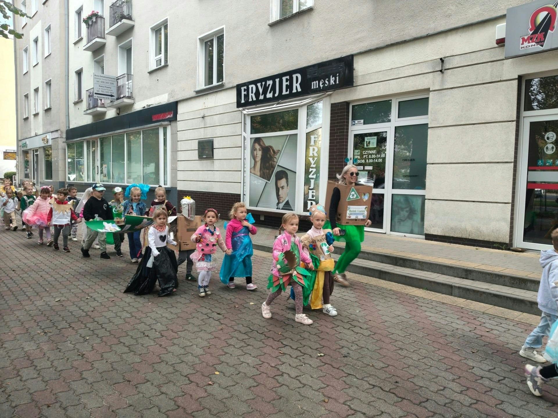 dzieci w przemarszu ulicami miasta